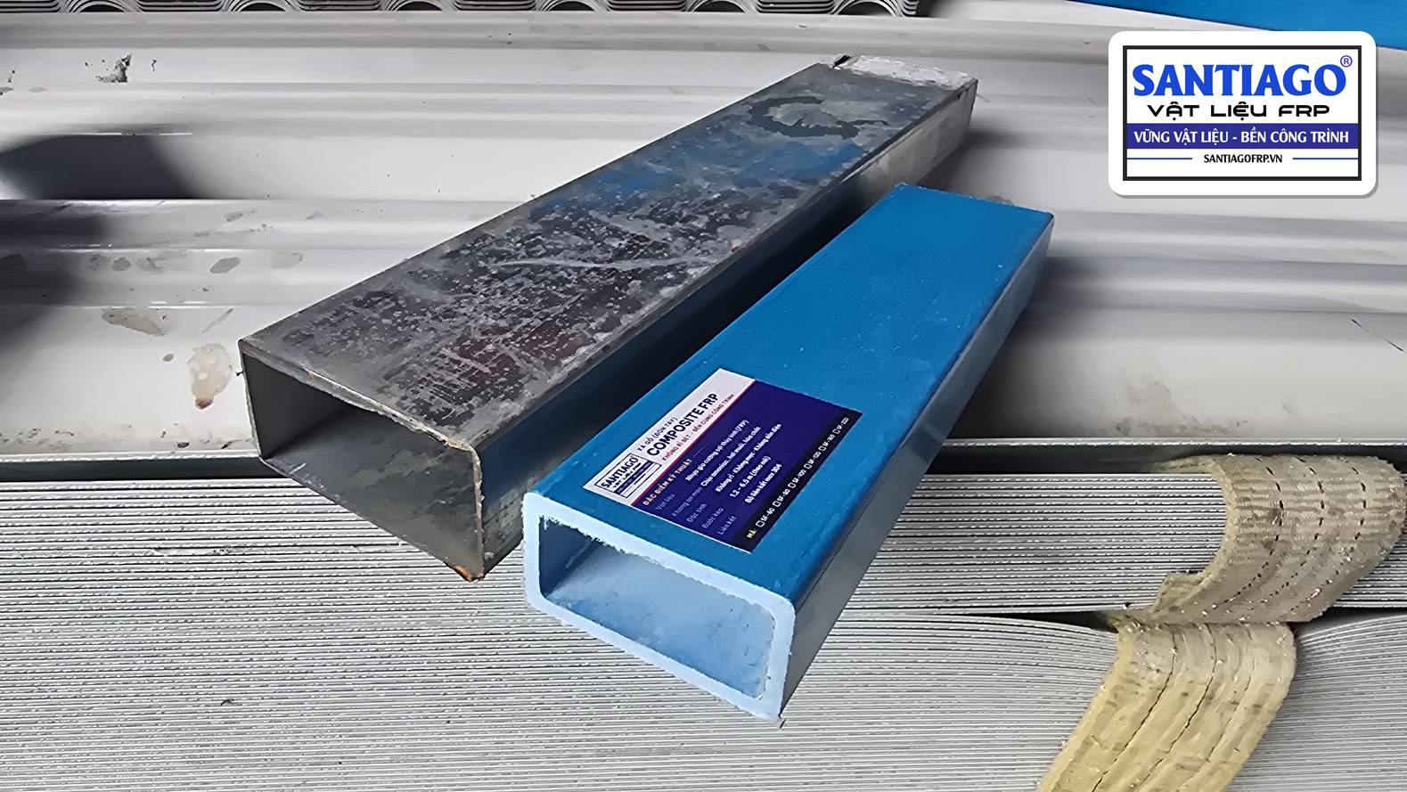 Hộp thép đã rỉ ở mép cắt đặt cạnh xà gồ composite màu xanh