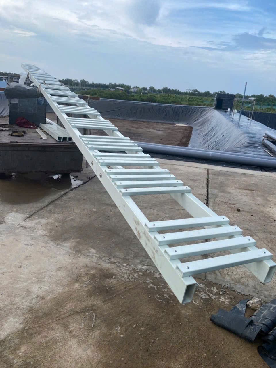 Cầu nhá composite đang lắp cạnh ao lót bạt