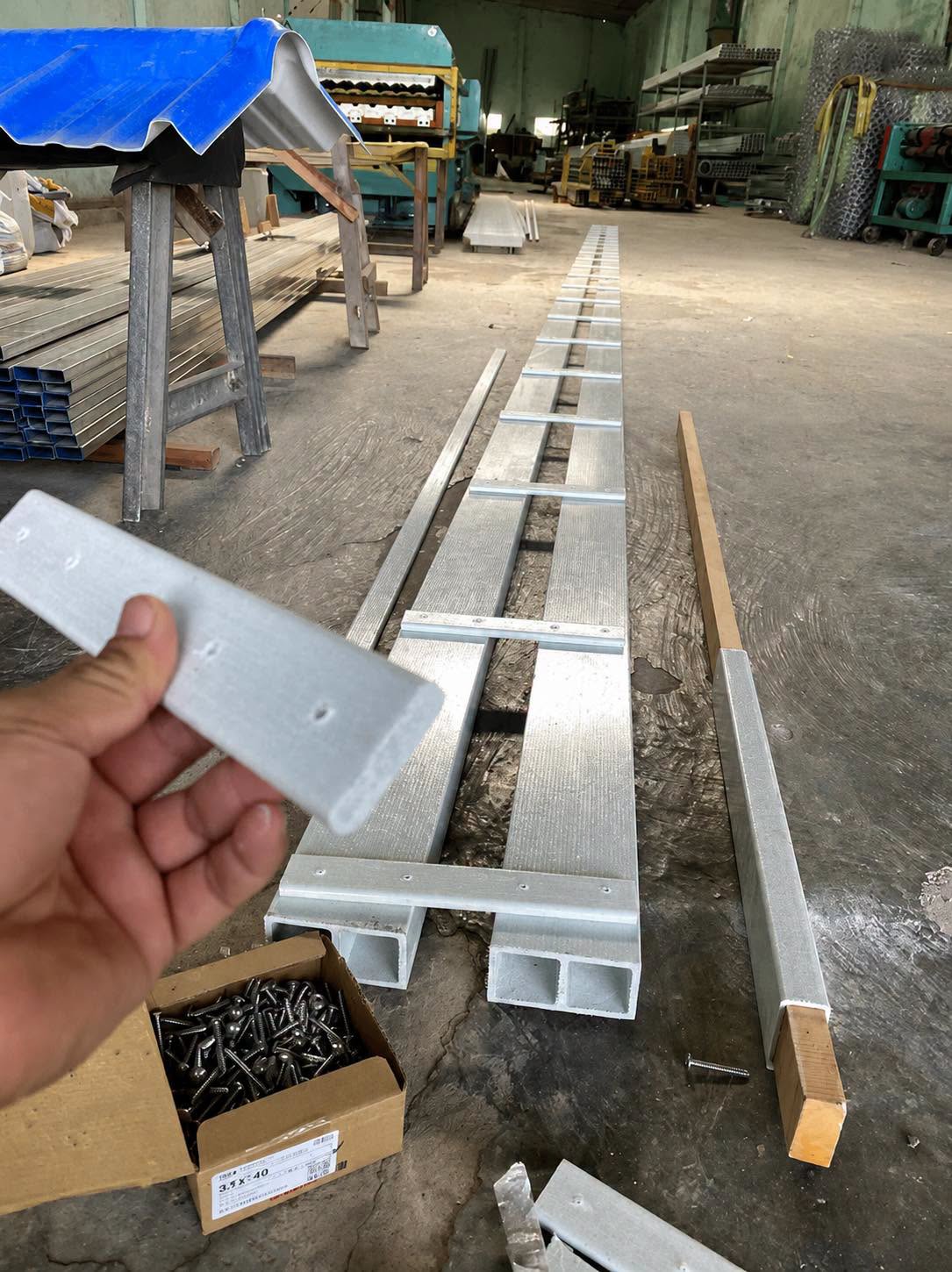 Bát nối inox cầm tay cạnh khung cầu nhá composite trong xưởng