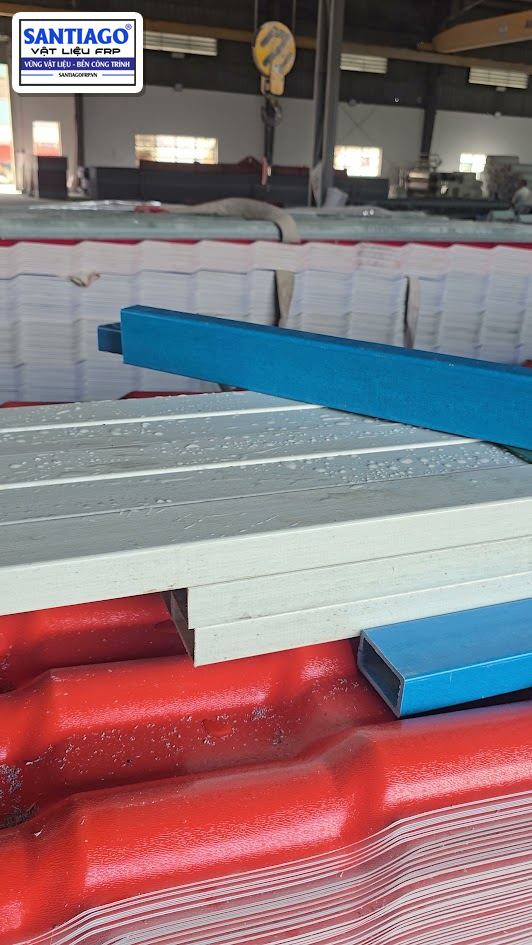 Thanh xà gồ composite xanh trên chồng xà gồ xám và kiện ngói nhựa