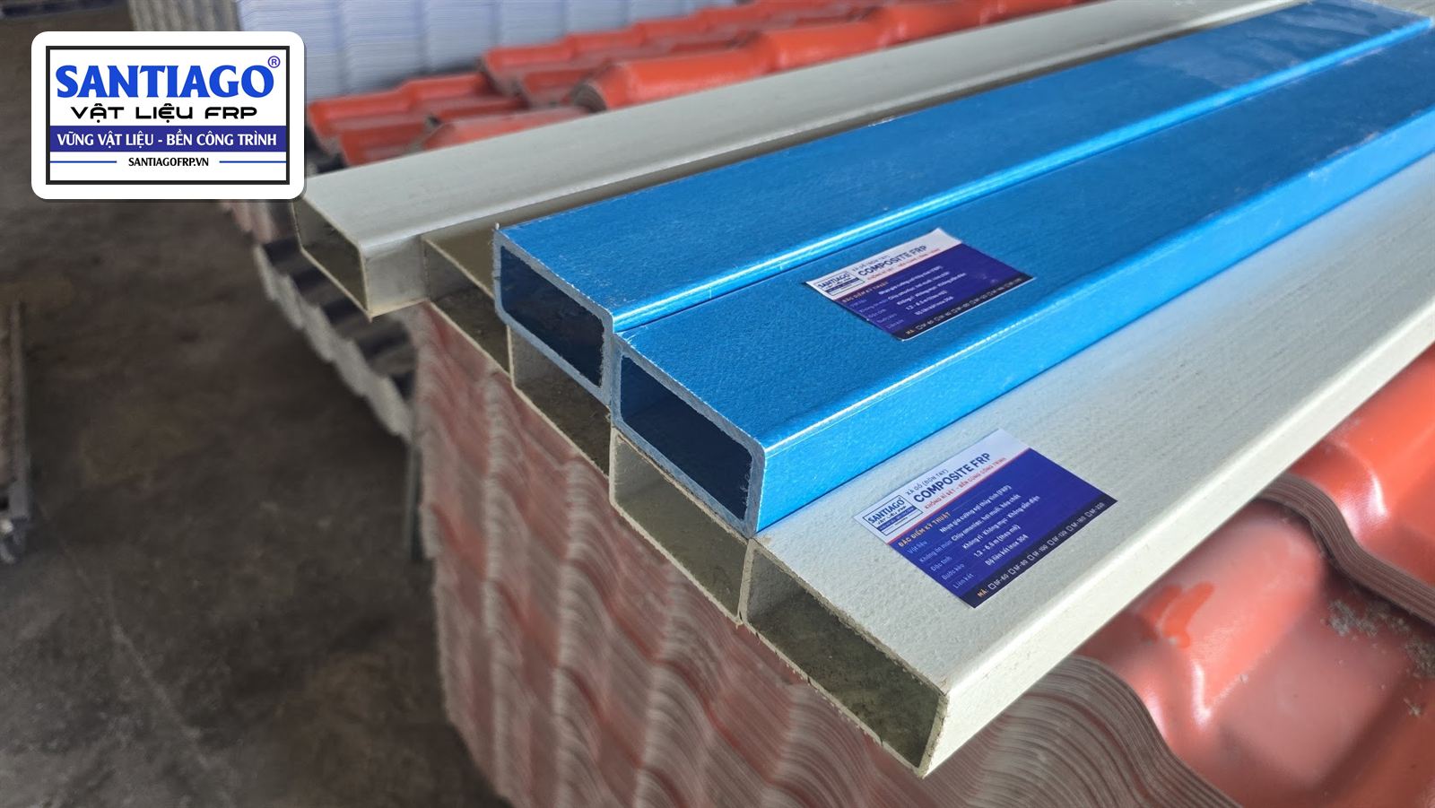 Xà gồ hộp composite xanh và xám xếp trên kiện ngói nhựa, có nhãn trên thân