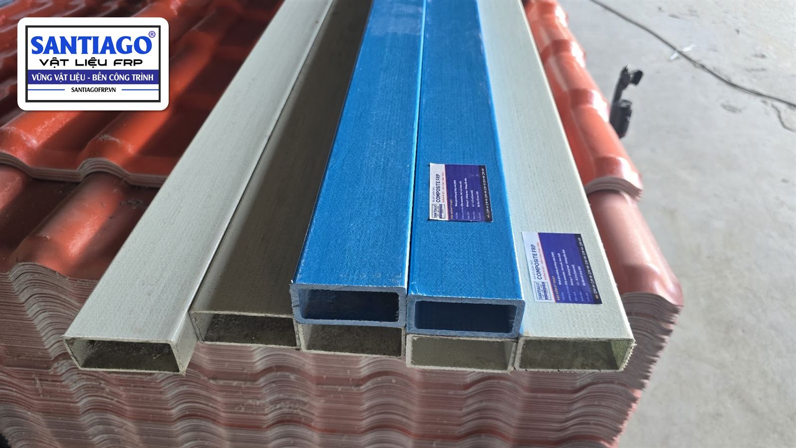 Bó xà gồ hộp composite xanh và xám nhìn từ đầu cây, xếp trên kiện ngói nhựa